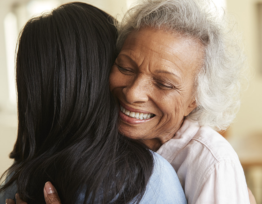 Older woman hugging another woman and smiling