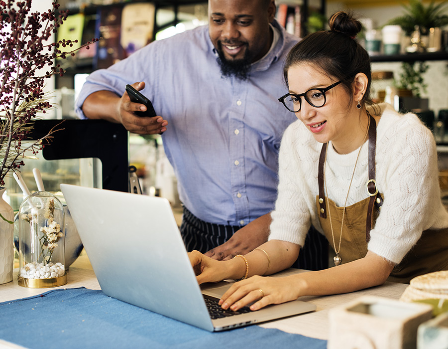 Woman on laptop while a man overlooks her shoulder