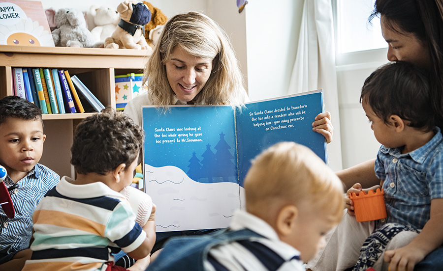 Woman reading story book to children